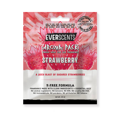 Everscents Aroma Pack under-seat car air freshener pouch. The upper half features a coral red and pink illustrated strawberry graphic over a pale pink  and light red brushstroke background with the brand text 'Everscents Aroma Pack' and the ‘Strawberry’ scent name, while the lower white half displays a text description of the scent profile and product information, shown isolated on a white background.